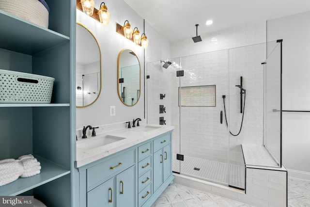 bathroom featuring double vanity, a stall shower, and a sink