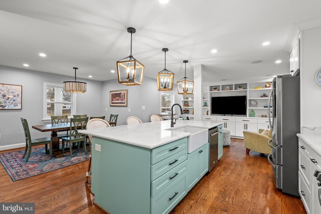 kitchen featuring appliances with stainless steel finishes, dark wood-style flooring, a sink, and white cabinets