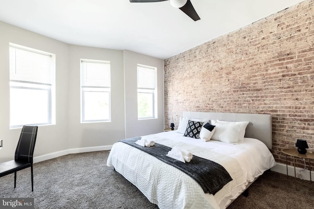 carpeted bedroom with brick wall, baseboards, and a ceiling fan