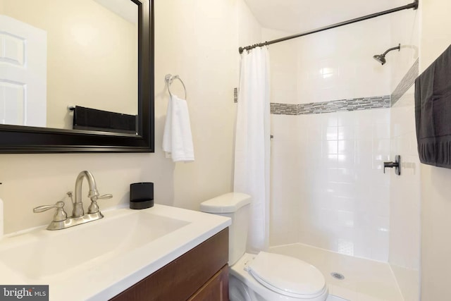 bathroom featuring a stall shower, vanity, and toilet