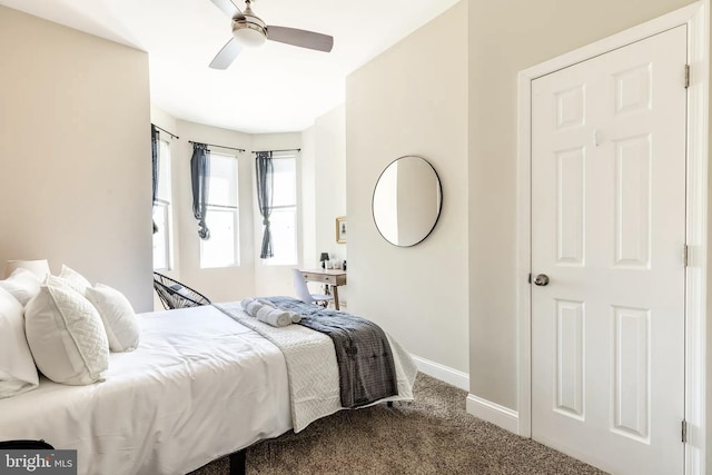 bedroom featuring baseboards, dark colored carpet, and a ceiling fan