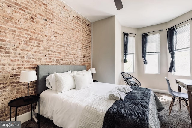 bedroom featuring carpet floors, brick wall, and multiple windows