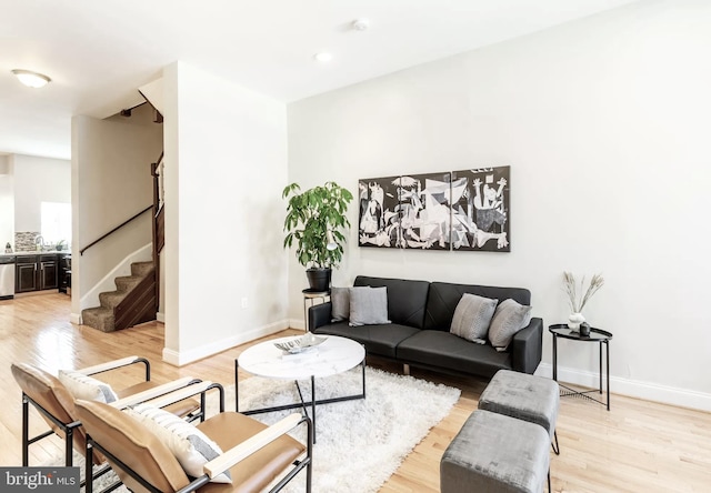 living room featuring light wood-style flooring, stairway, baseboards, and recessed lighting