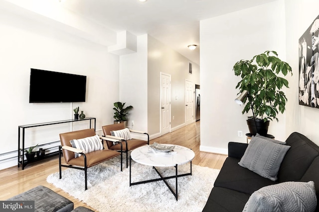 living area with light wood-style flooring and baseboards