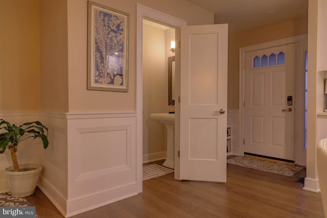 foyer with a wainscoted wall and wood finished floors