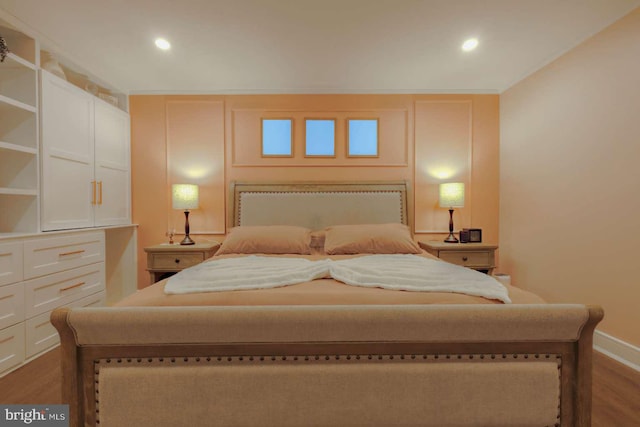 bedroom featuring baseboards, wood finished floors, and recessed lighting