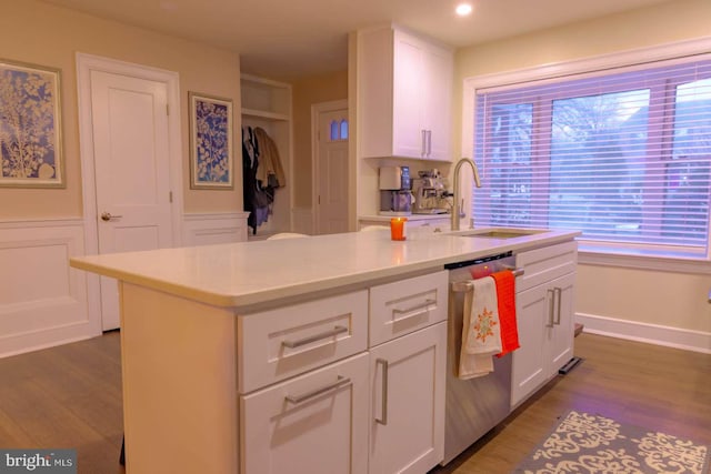 kitchen with light countertops, white cabinets, a sink, and stainless steel dishwasher