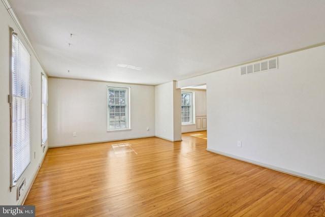 unfurnished room with ornamental molding, visible vents, and light wood-style floors