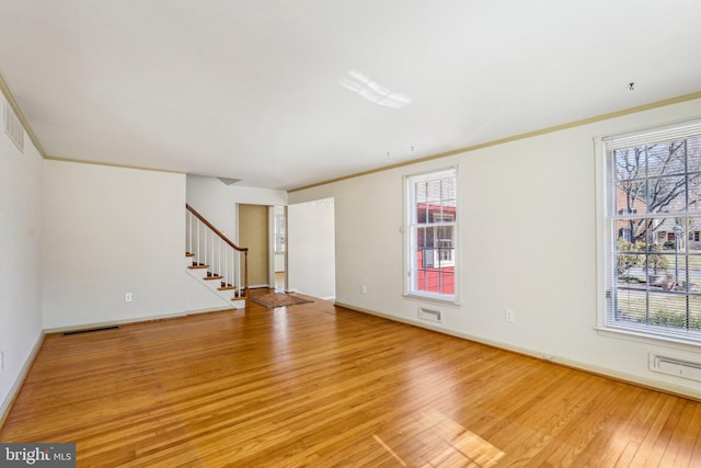 unfurnished living room with visible vents, baseboards, stairs, crown molding, and light wood-type flooring