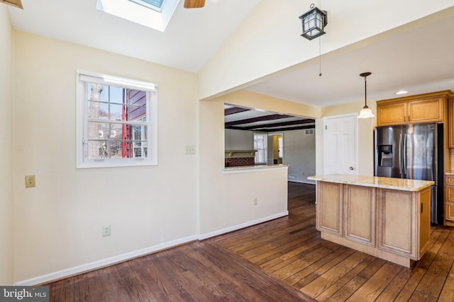 kitchen with dark wood-style floors, a center island, light stone countertops, vaulted ceiling with skylight, and baseboards