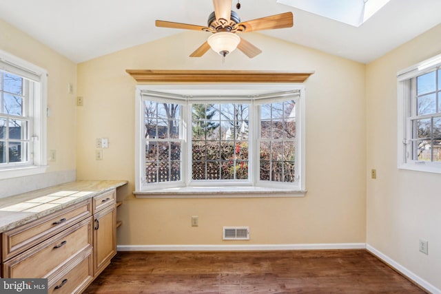 unfurnished dining area with lofted ceiling with skylight, dark wood-style floors, and visible vents