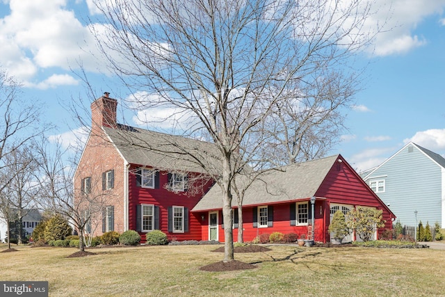 view of front facade featuring roof with shingles, a chimney, and a front lawn