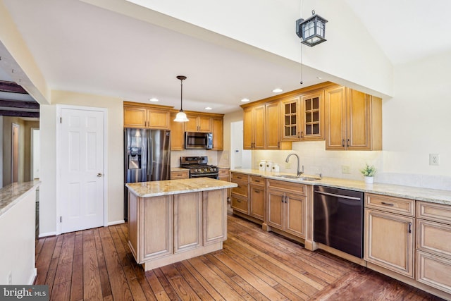 kitchen featuring a sink, vaulted ceiling, appliances with stainless steel finishes, light stone countertops, and dark wood finished floors