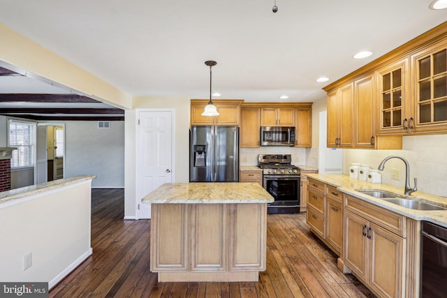 kitchen with light stone countertops, appliances with stainless steel finishes, dark wood-type flooring, and a sink