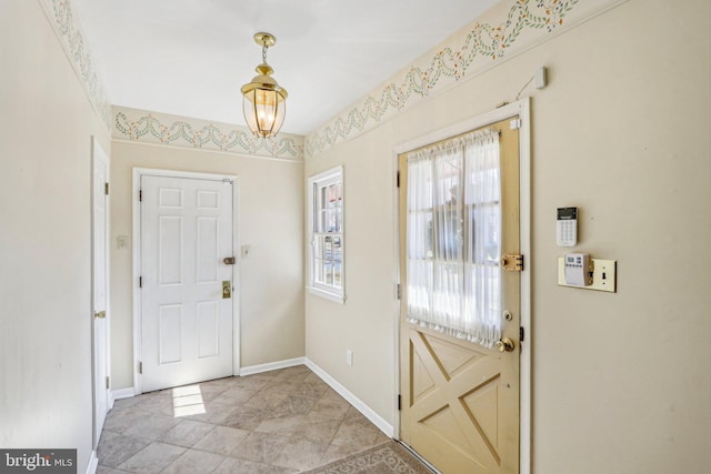 doorway to outside featuring baseboards