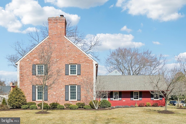 view of front of home with a front lawn and a chimney