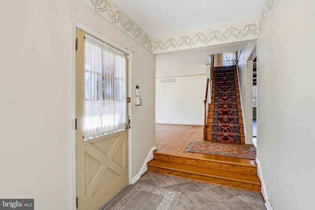 entryway with stairway, plenty of natural light, visible vents, and baseboards