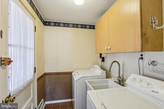 washroom with dark tile patterned floors, washing machine and clothes dryer, cabinet space, and wallpapered walls