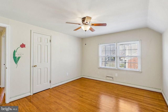 unfurnished bedroom featuring lofted ceiling, light wood-style floors, ceiling fan, and a baseboard heating unit