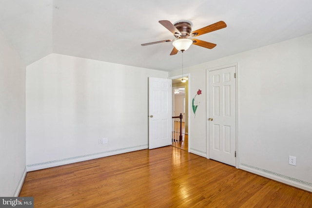 unfurnished bedroom with a ceiling fan, a baseboard radiator, baseboards, and wood finished floors