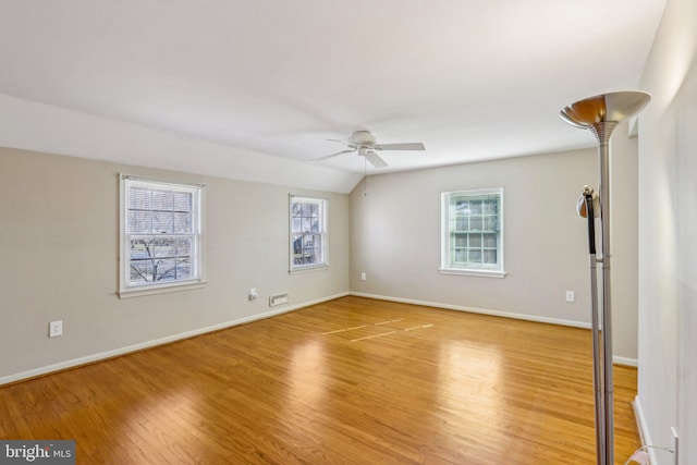 interior space featuring lofted ceiling, ceiling fan, light wood finished floors, and baseboards