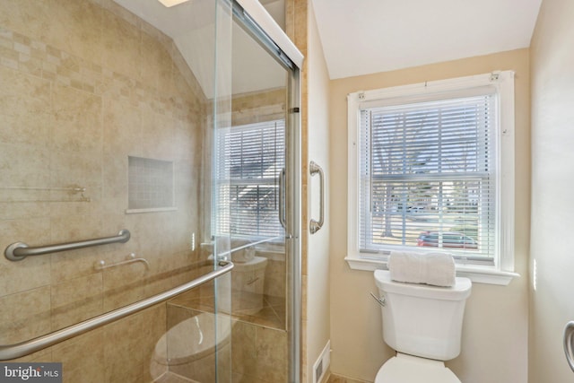 full bath featuring vaulted ceiling, a stall shower, and toilet