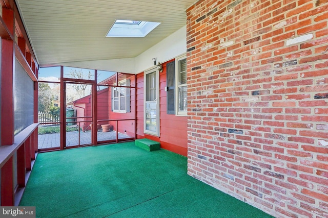 unfurnished sunroom with lofted ceiling with skylight