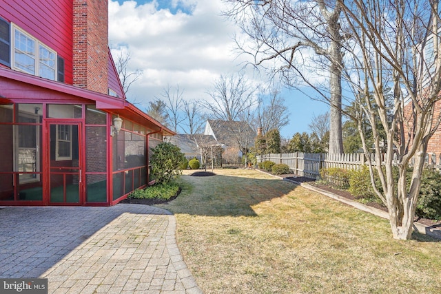 view of yard with a sunroom, fence, and a patio