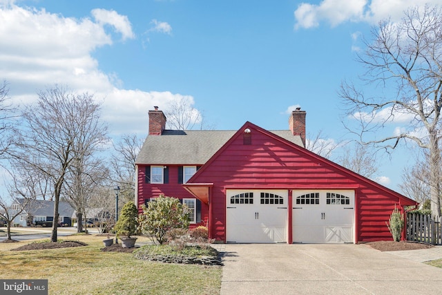 view of front of home featuring roof with shingles, a chimney, a front yard, fence, and a garage