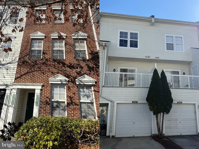 multi unit property featuring a garage, brick siding, and concrete driveway