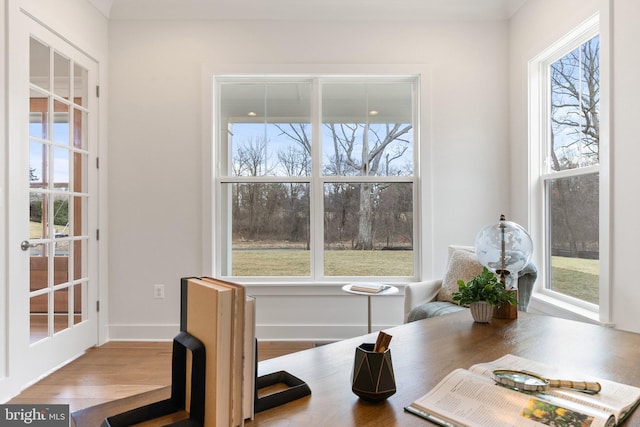 dining space with a wealth of natural light, baseboards, and wood finished floors