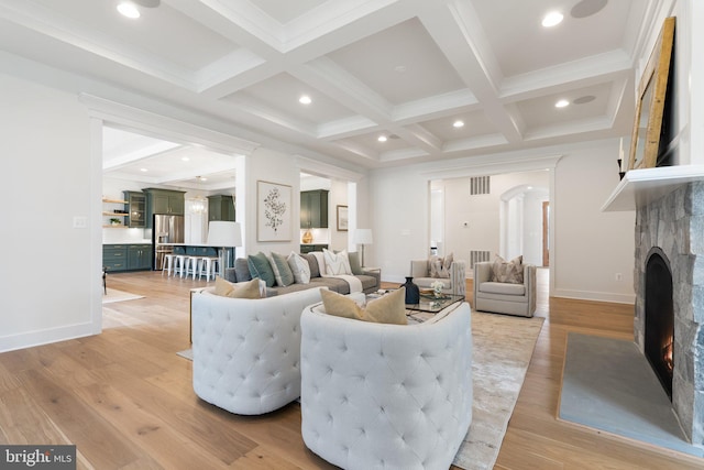 living room featuring coffered ceiling, a fireplace with flush hearth, light wood-style flooring, beamed ceiling, and recessed lighting