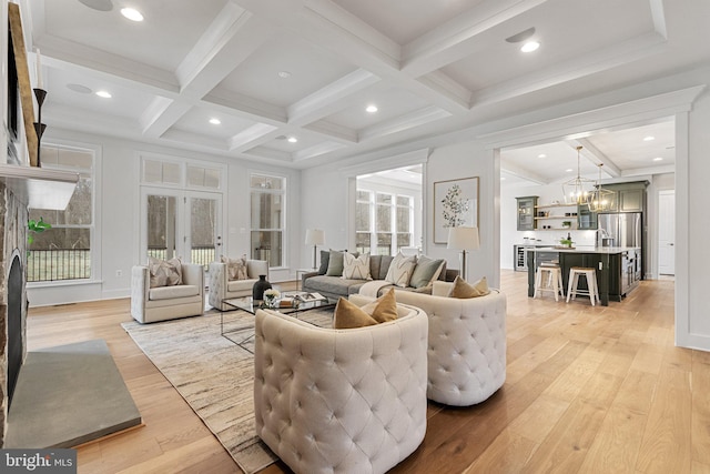 living room with a chandelier, coffered ceiling, beam ceiling, and light wood-style floors