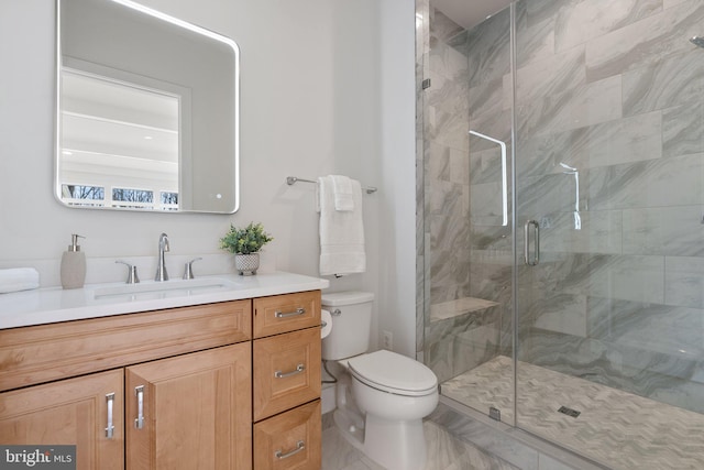 full bath featuring a stall shower, marble finish floor, vanity, and toilet