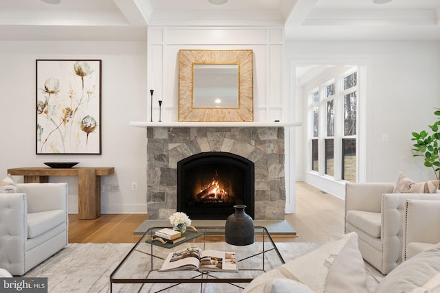 living room with beamed ceiling, a fireplace, wood finished floors, and baseboards