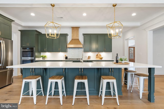 kitchen featuring a notable chandelier, premium range hood, green cabinets, and stainless steel appliances