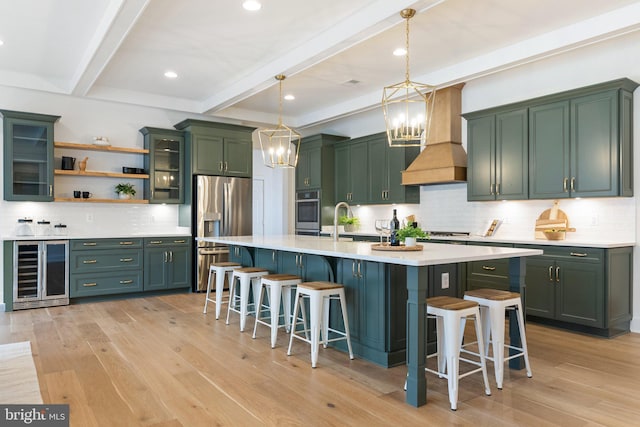 kitchen featuring light wood-style flooring, wine cooler, appliances with stainless steel finishes, and green cabinetry