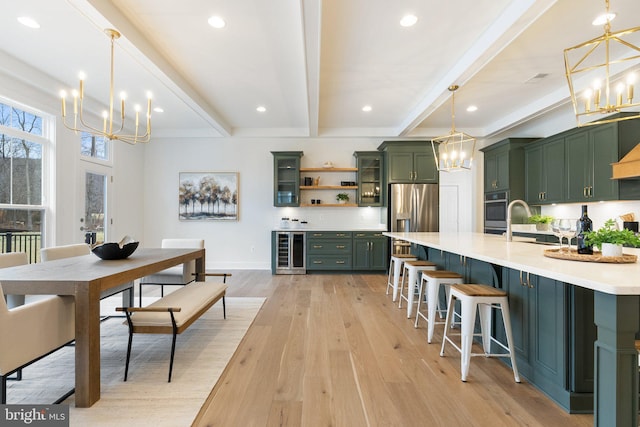 kitchen featuring wine cooler, a notable chandelier, light wood-style flooring, green cabinets, and stainless steel fridge