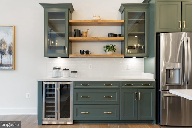 bar featuring baseboards, wine cooler, backsplash, and stainless steel fridge with ice dispenser