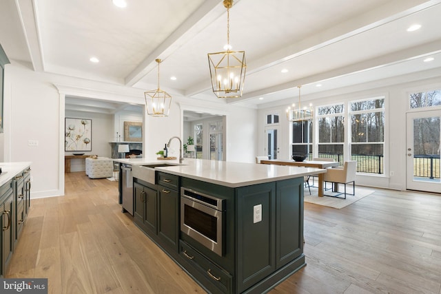 kitchen featuring stainless steel appliances, light countertops, light wood-style flooring, and an inviting chandelier