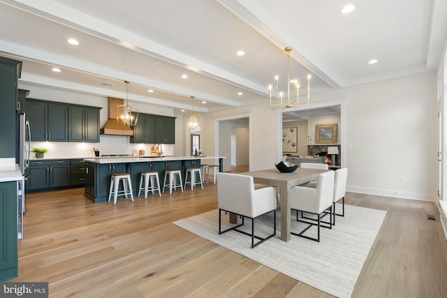 dining area with light wood finished floors, beamed ceiling, and an inviting chandelier