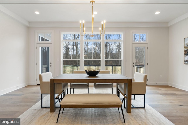 dining area featuring a chandelier, plenty of natural light, baseboards, and wood finished floors