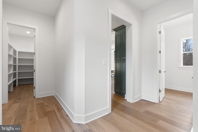 hall with light wood finished floors and baseboards