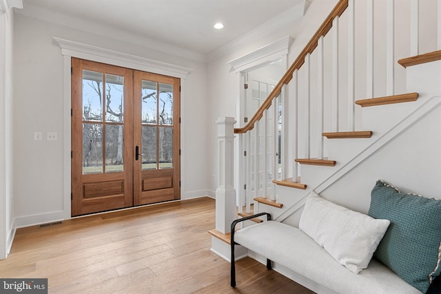 entryway with baseboards, visible vents, wood finished floors, stairs, and french doors