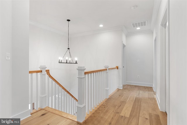 hallway featuring visible vents, wood finished floors, crown molding, an upstairs landing, and recessed lighting