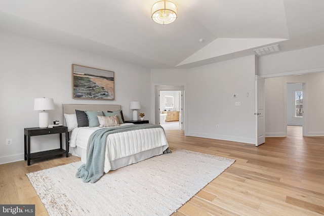 bedroom with lofted ceiling, light wood-style flooring, visible vents, and baseboards