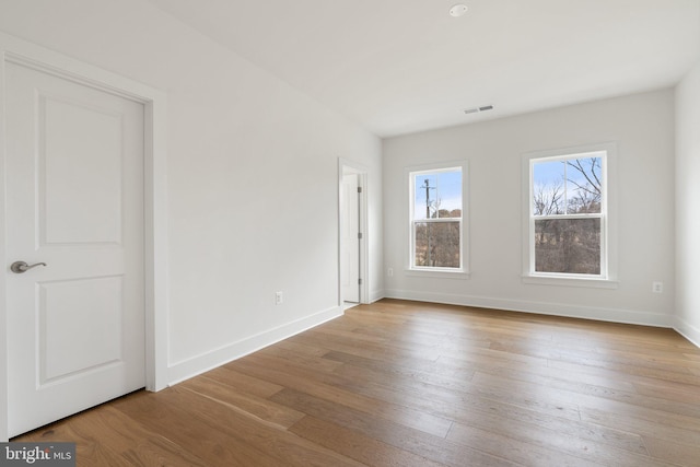 unfurnished bedroom with visible vents, baseboards, and wood finished floors