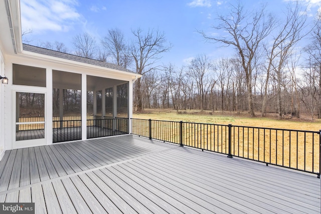 wooden terrace featuring a sunroom and a yard