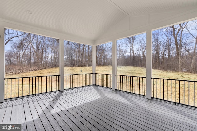 unfurnished sunroom featuring vaulted ceiling