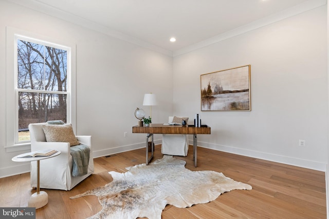 office featuring plenty of natural light, baseboards, crown molding, and wood finished floors